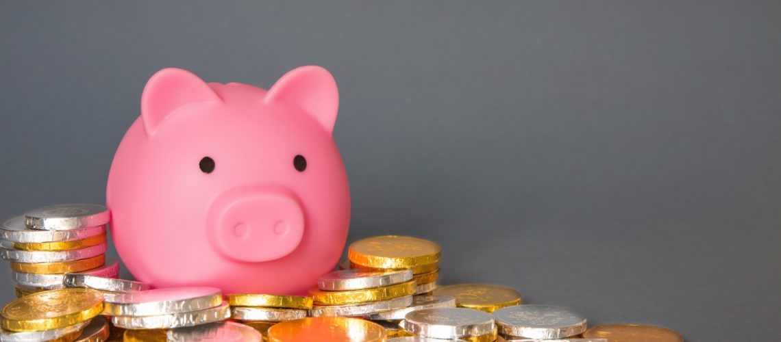 a-savings-or-home-finance-concept-with-a-pink-toy-piggy-bank-or-money-box-surrounded-by-cash-coins_t20_ZYaLlo