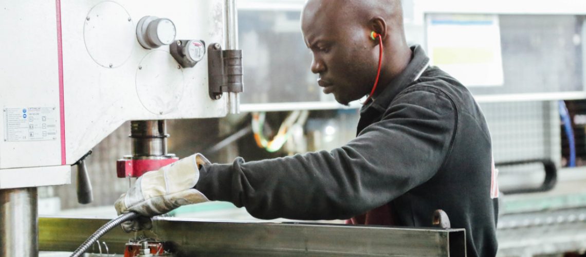 black-man-working-in-manufacturing-on-industrial-machine_t20_x60G3l