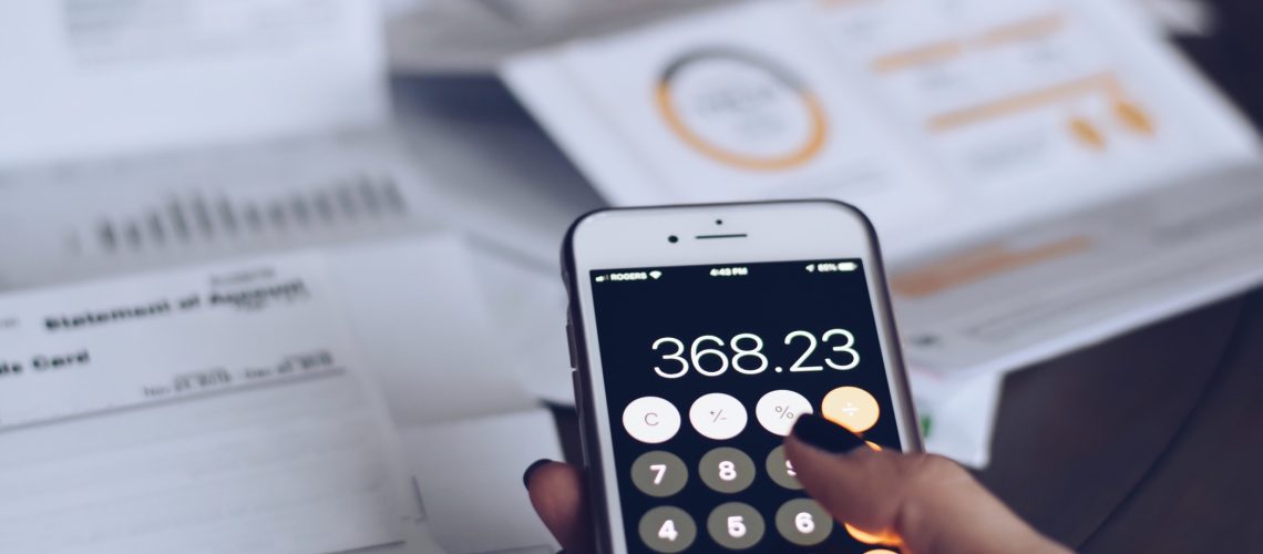 scattered-bills-and-credit-card-statements-on-a-desk-post-holiday-debt-female-hand-using-calculator_t20_eVwNg7